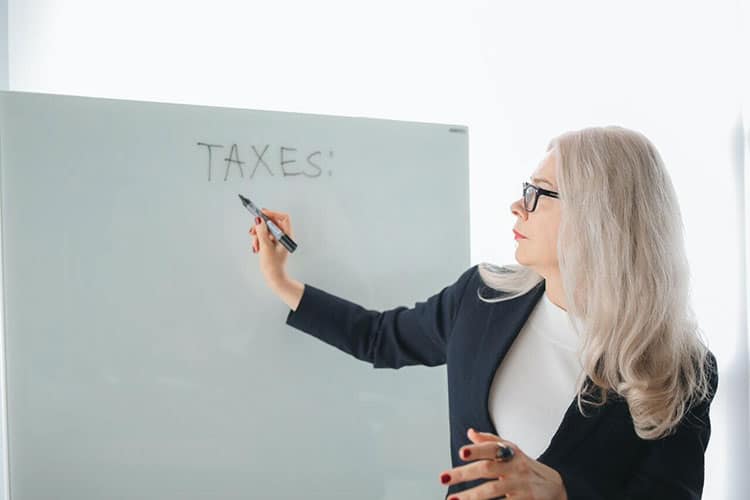 Image of Canadian tax lawyer with glasses writing guide to third party tax liabilities on white board