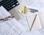 A picture of unpaid taxes by a director with a post it note on a laptop reading ”tax deadline