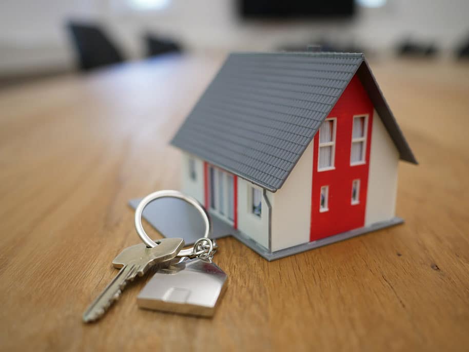Picture of small home and large keys on wood table