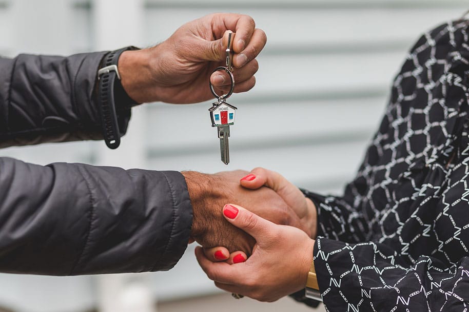 Two people holding hands, one holding home key on it