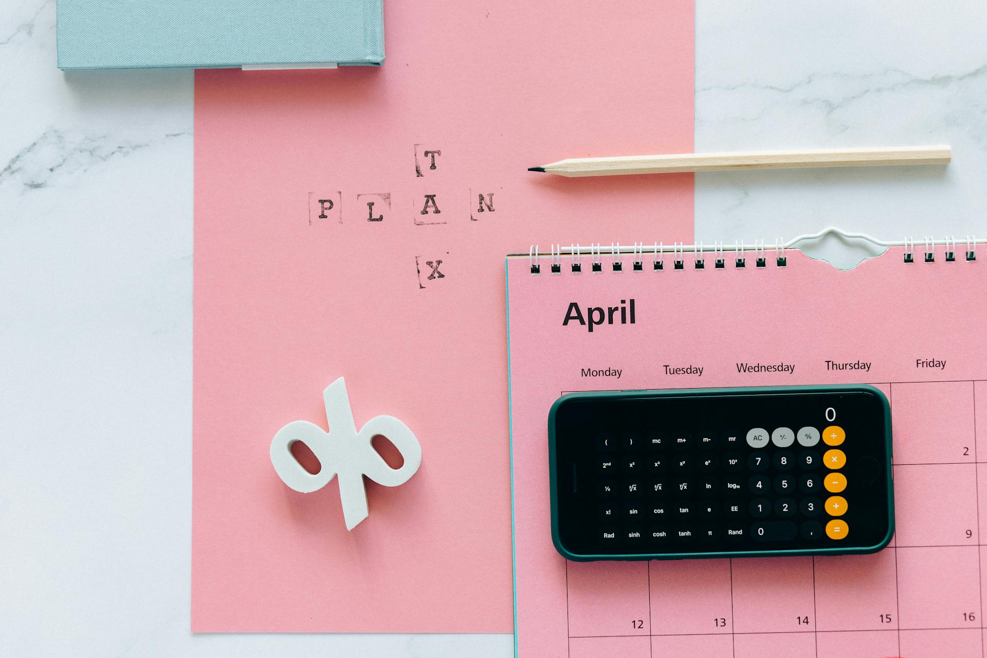 Pink April calendar beside pink piece of paper that says tax plan