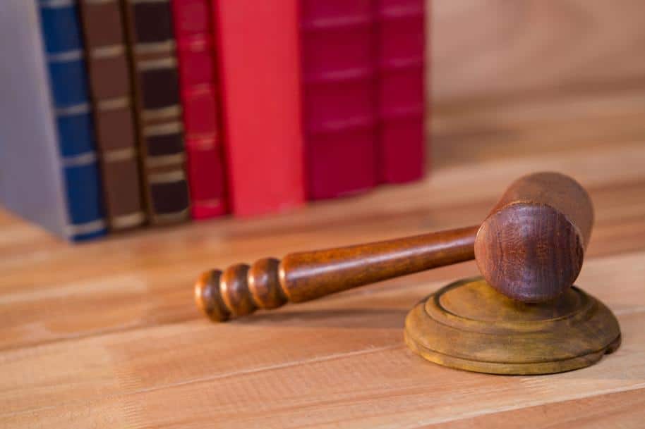 Closeup of a gavel with law books in the background