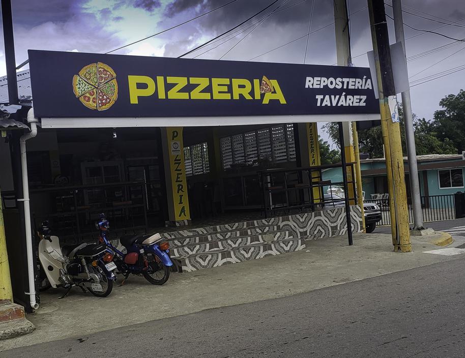 Exterior of a pizzeria with signage written in Spanish.